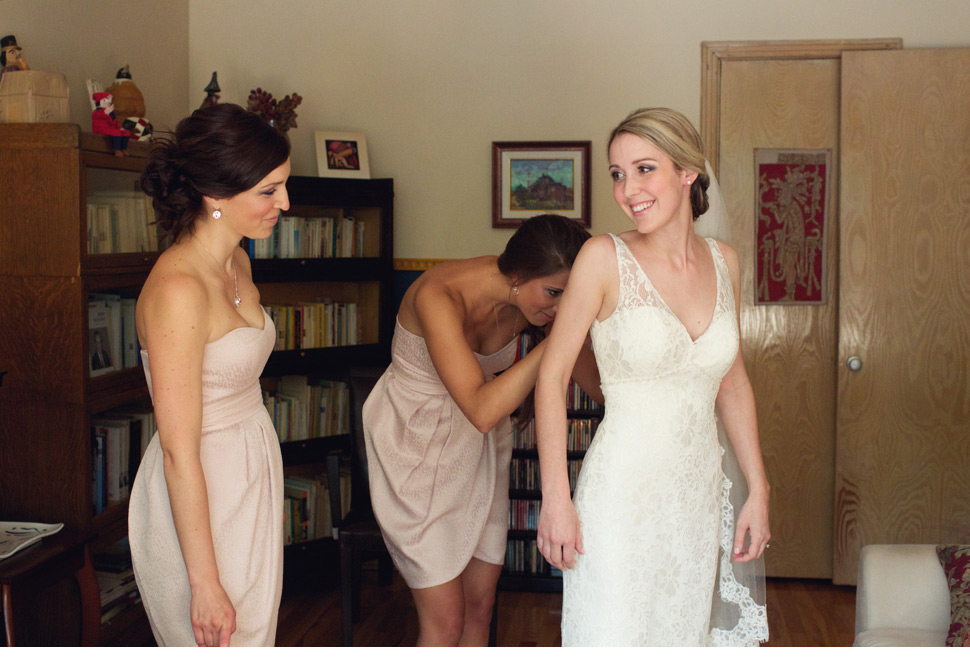 Laçage de la robe de mariée avec les filles d'honneur.